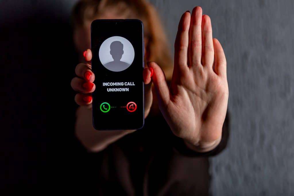 Phone call from unknown number. Scam, fraud or phishing with smartphone concept. Prank caller, scammer or stranger. Woman answering to incoming call. Timeshare exit scammer with fake identity