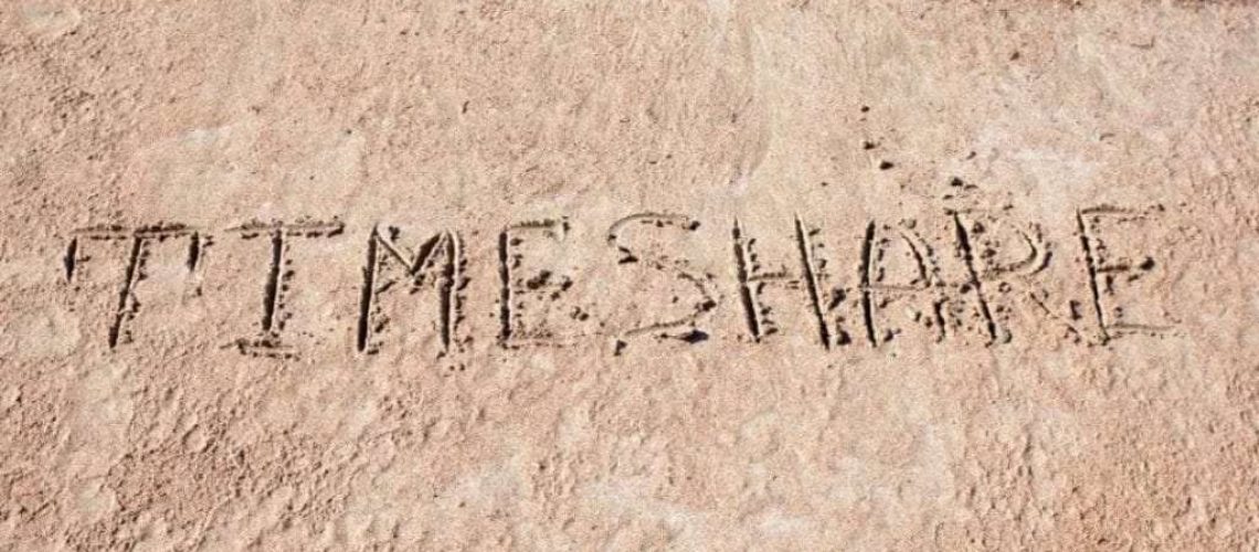 a beach with timeshare written in the sand